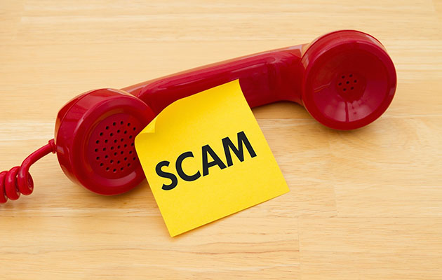A read phone with a post-it note reading "scam"